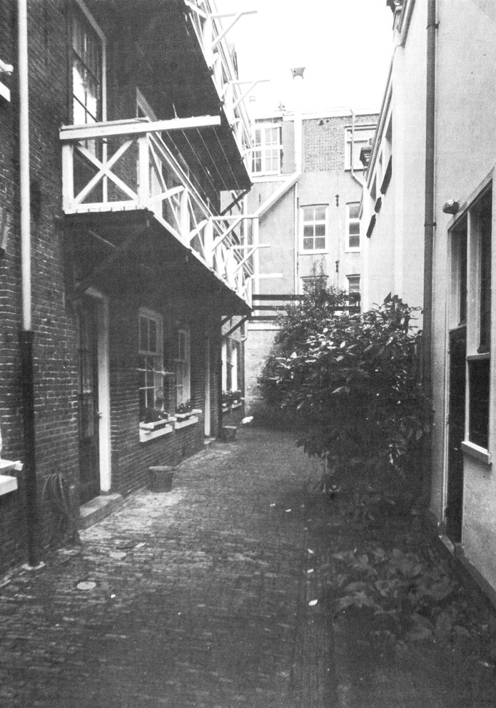 Het kleine binnenplaatsje. 
Links huizen De Lely, rechts het kleine deurtje 
dat toegang geeft tot de conversatiekamer.